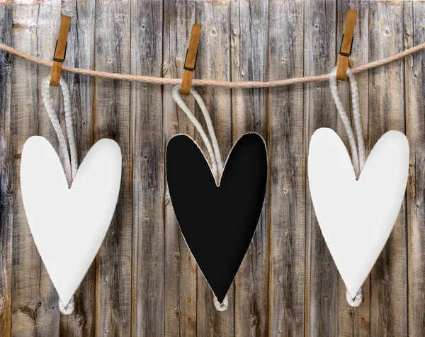 Three black and white hearts hang on the rope — Stock Photo, Image