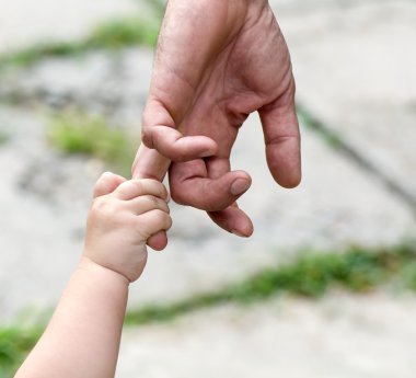 çocuk babasının elini parmağını tutan