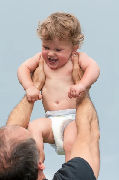 Homem cria uma criança em suas mãos — Fotografia de Stock
