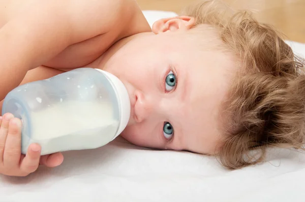 Piccolo bambino succhia una bottiglia di latte — Foto Stock