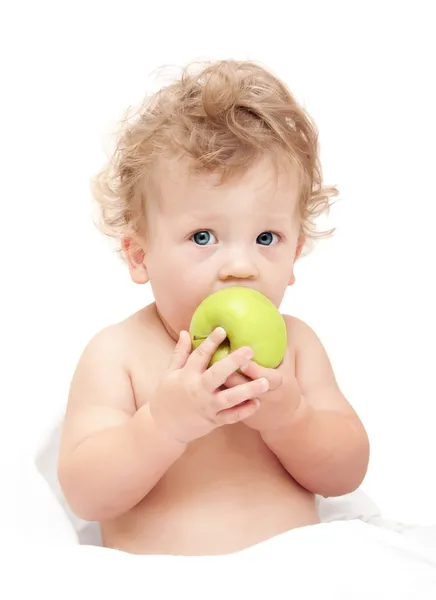Portré egy gyermek göndör haj eszik egy zöld alma — Stock Fotó