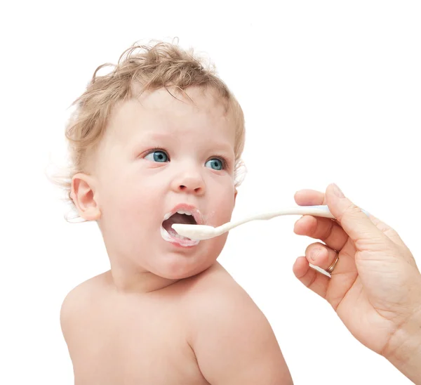 Mother feeds small child with spoon Stock Photo
