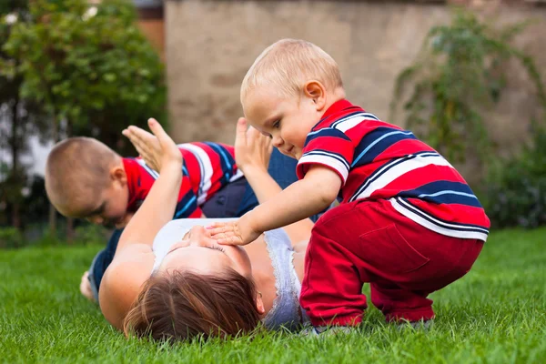 Giovane donna che gioca con i bambini all'aperto — Foto Stock