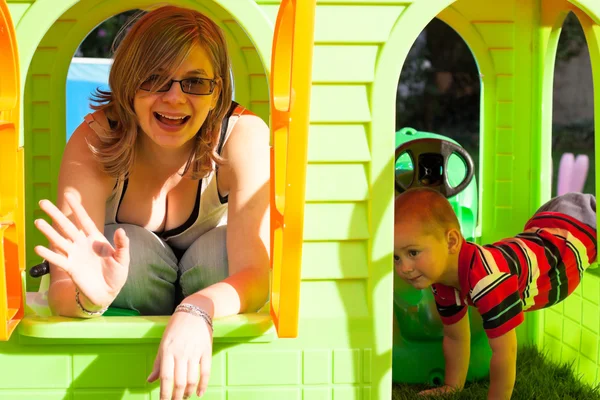 Gelukkige vrouw en kind in playhouse — Stockfoto