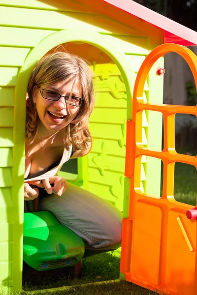 Смешная женщина, играющая в домике для игр — стоковое фото