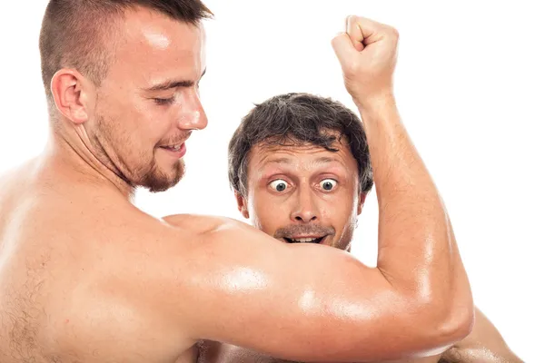 Grappige mannen kijken naar biceps — Stockfoto