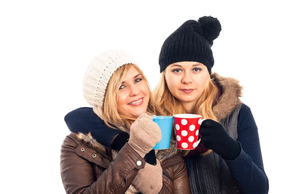 Две женщины в зимней одежде держат кружку — стоковое фото