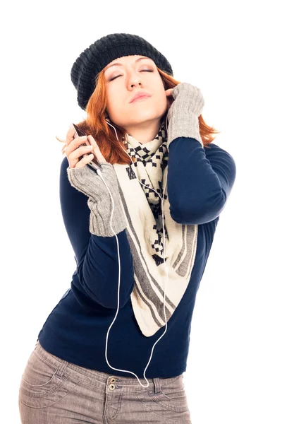 Молода жінка в зимовому одязі слухає музику — стокове фото
