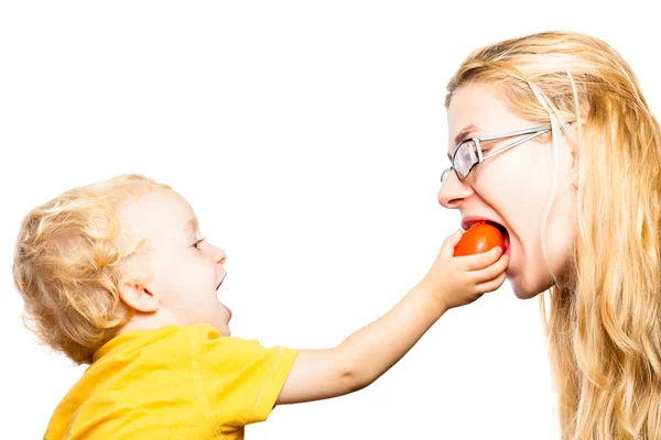 Divertido niño y mujer comiendo tomate — Foto de Stock