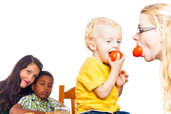 Mujer divertida y niño comiendo tomate —  Fotos de Stock