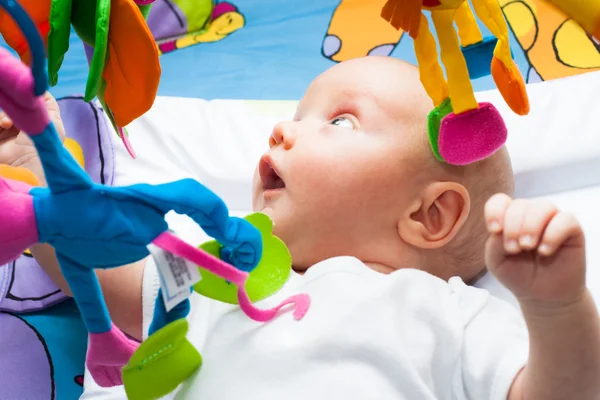 Menino feliz na cama com brinquedos — Fotografia de Stock