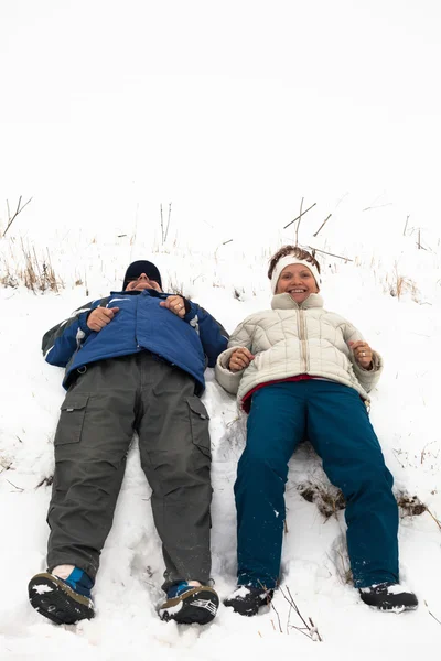 Casal feliz descansando na neve — Fotografia de Stock