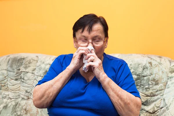 Oudere vrouw waait neus — Stockfoto