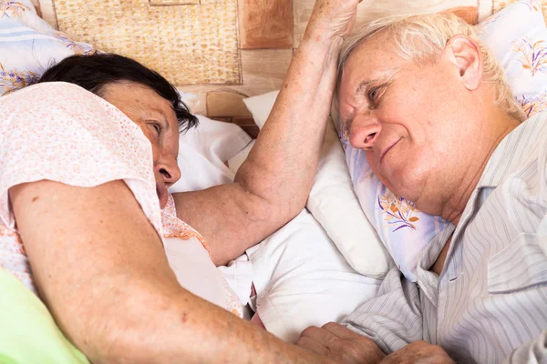 两个老人放松躺在床上 — 图库照片