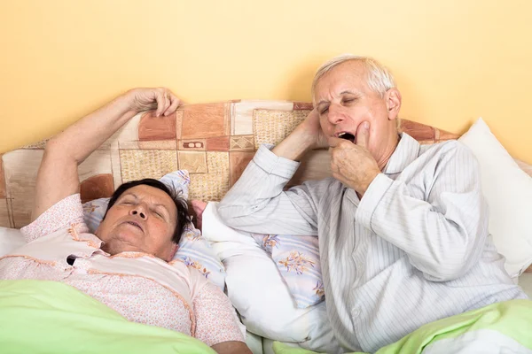 Sömnig äldre par i sängen — Stockfoto