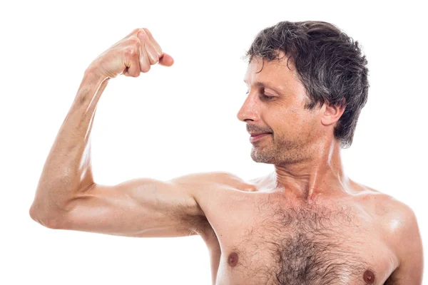 Štíhlý muž při pohledu na biceps — Stock fotografie