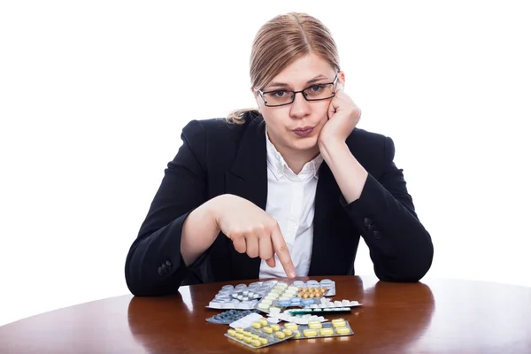 Serious woman pointing at pills — Stock Photo, Image