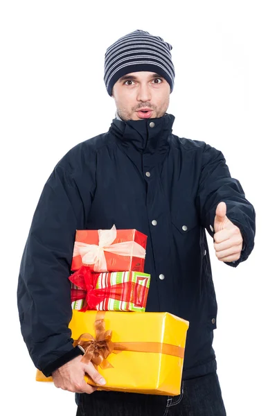 Förvånad man med presenterar tummen upp — Stockfoto