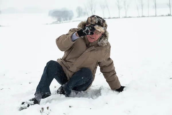 Winterunfall eines Seniors Stockbild