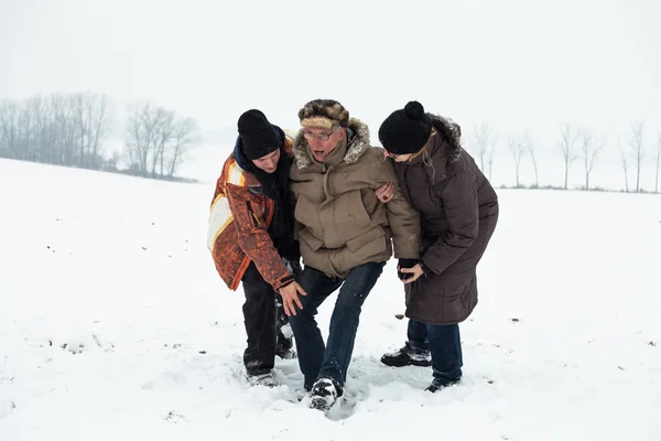 Senior sneeuw ongeval en mensen helpen hem — Stockfoto