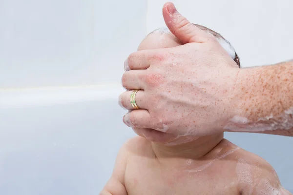 Baby boy in bath and hand covering his face — Stock Photo, Image