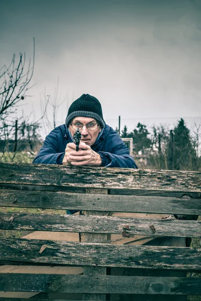 Homem sênior apontando uma arma — Fotografia de Stock