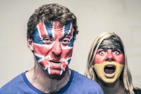 Couple effrayant avec drapeau britannique et allemand sur le visage — Photo