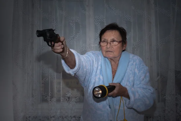 Starší žena s pistolí a pochodeň — Stock fotografie