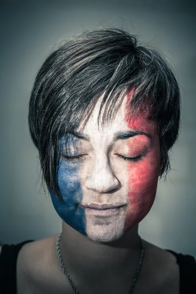 Mulher com bandeira da França no rosto e olhos fechados — Fotografia de Stock