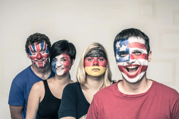 Смешные люди с нарисованными флагами на лицах — стоковое фото