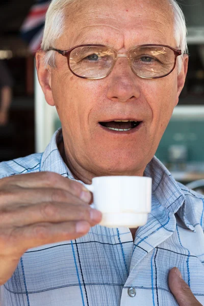 Starší muž pije kávu — Stock fotografie