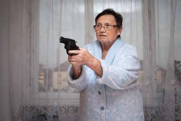 Senior woman with a gun — Stock Photo, Image