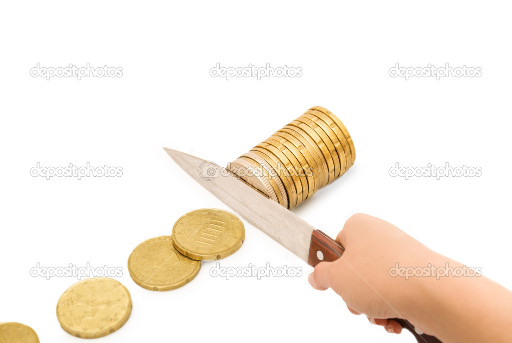 Knife cutting a pile of coin. Concept of budget cuts, savings, recession