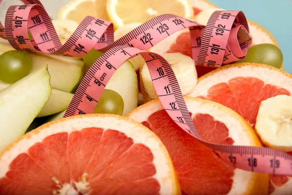 Fresh fruit with measuring tape background — Stock Photo, Image