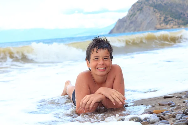 Glada leende pojke på havsstranden — Stockfoto