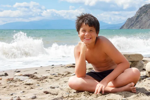 Feliz menino sorridente na praia do mar — Fotografia de Stock