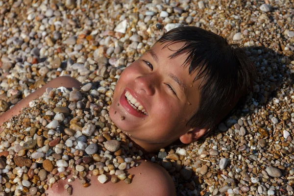 Glad ung pojke på havsstranden — Stockfoto