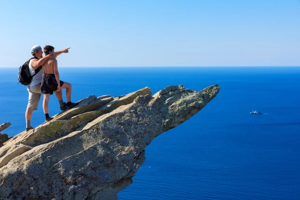 Father on a mountaintop shows son ship far out at sea — Stock Photo, Image