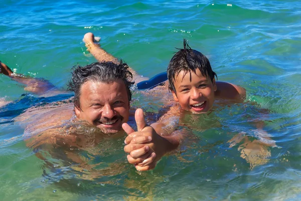 Gelukkig zwemmers vader en zoon in de zee — Stockfoto