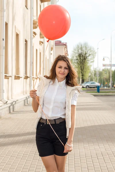 Hermosa chica de moda con globo rojo en la calle —  Fotos de Stock