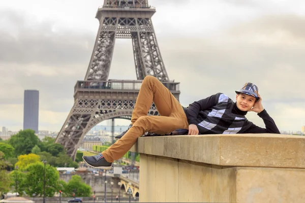 Jonge man hipster op de achtergrond van de Eiffeltoren, Frankrijk — Stockfoto