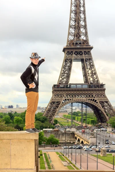 Jonge man hipster toont de Eiffeltoren, Frankrijk — Stockfoto