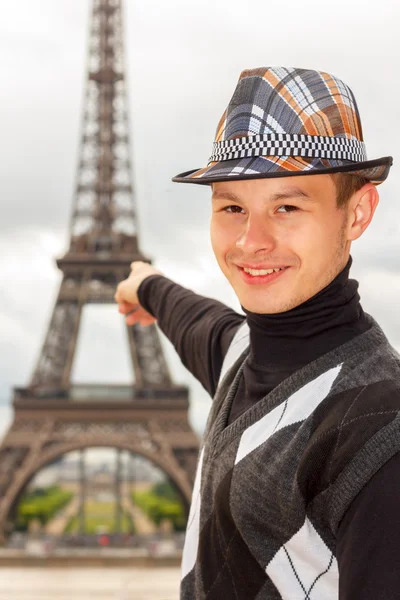 Young man hipster shows the Eiffel tower, Paris, France — Stock Photo, Image