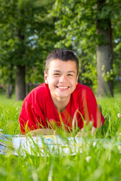 Laughing teenage summer lies in the grass — Stock Photo, Image