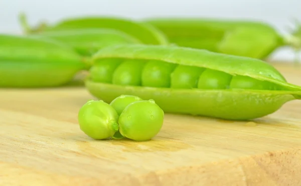 Una vaina de guisantes abierta con guisantes — Foto de Stock