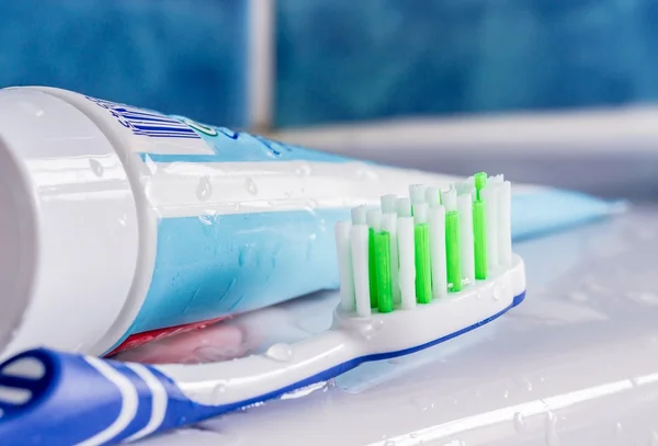 Un cepillo de dientes junto a un tubo de pasta dental —  Fotos de Stock