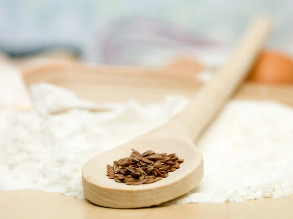 Seeds of flax placed on wooden spoon — Stock Photo, Image