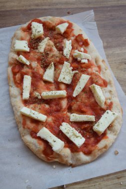 Mozarella peynirli ve domatesli ev yapımı pizza.