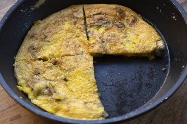 Yumurtalı frittata üç parçaya bölünmüş ve tavada pişirilmiş.
