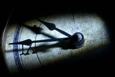 Roma rakamlarının saatleri gösterdiği eski bir saat yüzüyle zamanın ayrıntıları